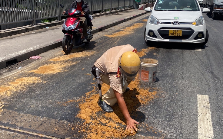 Phát hiện dầu nhớt đổ loang trên đường, CSGT TP.HCM xin cát rải để tránh tai nạn