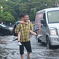 Mưa lớn giờ tan trường ở TP.HCM, phụ huynh lội nước cõng con về nhà