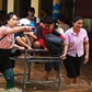 Giáo viên đẩy xe đưa học sinh qua vùng ngập